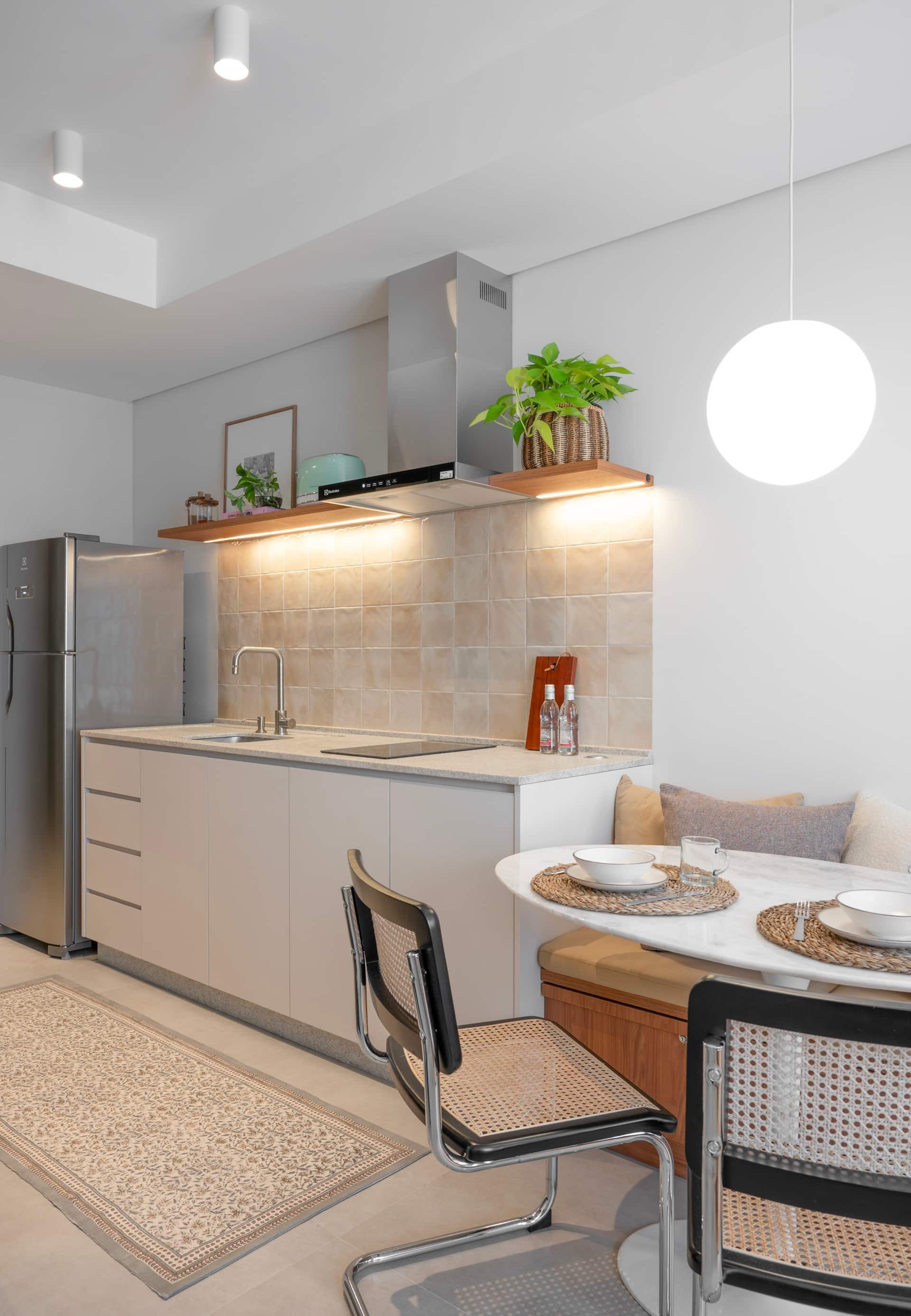 Cozinha com geladeira, cooktop e mesa de jantar redonda
